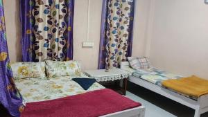 a room with a bed and a couch and curtains at Melody residency in Cherrapunji