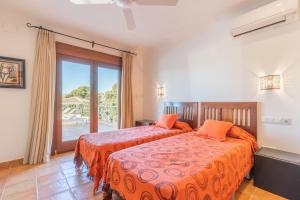 a bedroom with two beds and a balcony at Casa Once Moraira in Teulada +22 photos