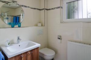 a bathroom with a sink and a toilet and a mirror at Ferienwohnung Kramer in Überlingen +18 photos