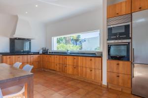 a kitchen with wooden cabinets and a window at Casa Once Moraira in Teulada