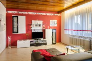 a living room with red walls and a tv at Ferienwohnung Kramer in Überlingen