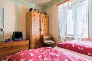 a bedroom with a bed and a cabinet and a tv at Casa Sicina Alberto in Valfloriana