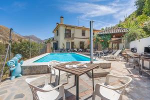 a villa with a swimming pool and a house at Casa Hitos in Monachil