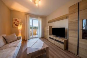 a living room with a couch and a television at Residence Kronstein - Fewo 5 in Tesimo