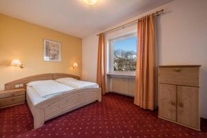 a bedroom with a bed and a large window at Residence Kronstein - Fewo 5 in Tesimo