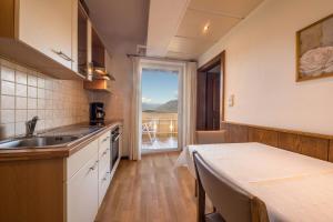 a kitchen with a sink and a table and a window at Residence Kronstein - Fewo 5 in Tesimo