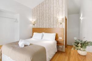 a bedroom with a large white bed with white pillows at Casa do Calhau in Câmara de Lobos