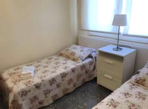 a small bedroom with two beds and a night stand at Apartamento Francás in Comarruga +16 photos
