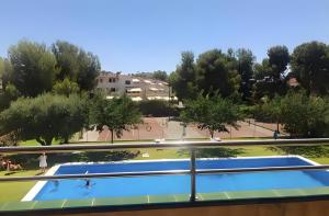 a view of a swimming pool from the balcony of a building at Apartamento Francás in Comarruga