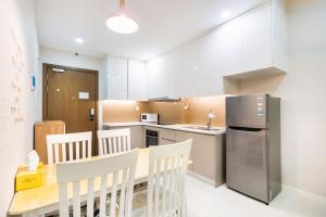 a kitchen with a table and chairs and a refrigerator at Boscolos Apartment in Ho Chi Minh City
