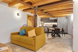 a living room with a yellow couch and a table at La Maison du Brenand in Rhêmes-Notre-Dame