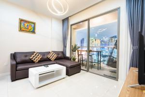 a living room with a leather couch and a balcony at Boscolos Apartment in Ho Chi Minh City