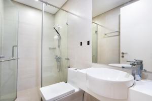 a white bathroom with a sink and a shower at Boscolos Apartment in Ho Chi Minh City