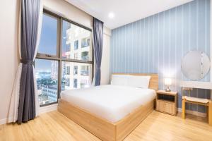 a bedroom with a bed and a large window at Boscolos Apartment in Ho Chi Minh City