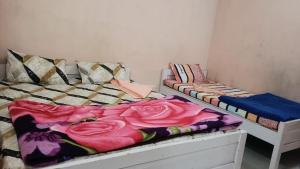two beds in a room with colorful blankets at Melody residency in Cherrapunji