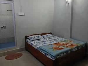 a small bedroom with a bed with a shower at Melody residency in Cherrapunji