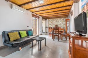 a living room with a couch and a flat screen tv at Casa Petra in Illora