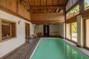 an indoor pool in a house with a wooden ceiling at Ferme de Faustine 2 - piscine in Saint-Gervais-les-Bains
