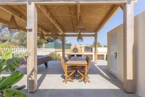 a wooden pavilion with a table and chairs on a patio at Can Juan Pedro in La Mola