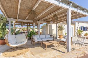 an outdoor patio with chairs and a swing at Can Juan Pedro in La Mola