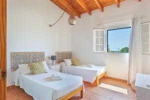 a room with two beds and a couch and a window at Can Juan Pedro in La Mola +20 photos