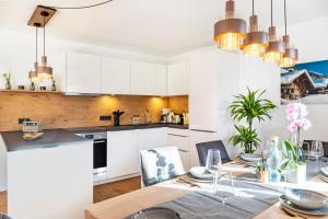 a kitchen and dining room with white cabinets and a table at Apartment Luisa in Scharnitz