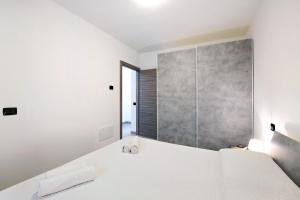 a bedroom with a white bed with two shoes on it at Appartamento 4 in Nesso