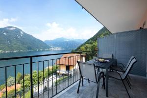 a balcony with a table and chairs and a view of a lake at Appartamento 4 in Nesso
