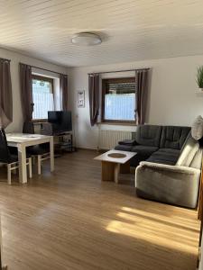 a living room with a couch and a table at Ferienwohnung M Keller in Hollfeld +2 photos