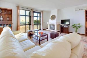 a living room with a white couch and a television at Villa Albuar in Patroves