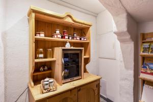 a room with a wooden shelf with a tv at Florerhof Ferienwohnung Flieder in Vols am Schlern
