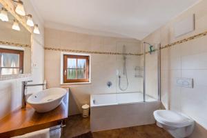 a bathroom with a tub and a toilet and a sink at Florerhof Ferienwohnung Flieder in Vols am Schlern +19 photos