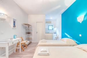 a room with two beds and a desk in it at Pleasure Corfù Fish in Agios Georgios