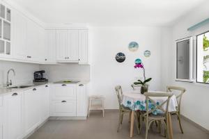 a kitchen with white cabinets and a table and chairs at El Pasero in El Golfo