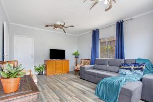 a living room with a couch and a tv at Casa da Ribeira da Janela in Porto Moniz