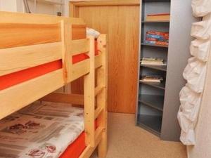 a bedroom with bunk beds and a book shelf at Waldhaus Jakober in Maasdorf