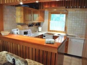 a kitchen with wooden cabinets and a counter top at Waldhaus Jakober in Maasdorf