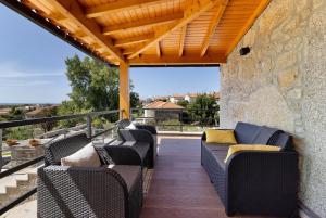 a patio with wicker furniture and a stone wall at Casa da Lage in Castelo do Neiva