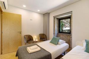 a bedroom with two beds and a window at Casa da Lage in Castelo do Neiva