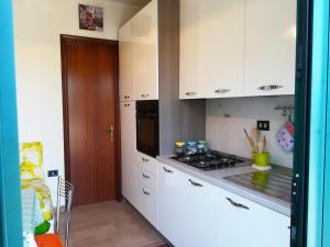 a kitchen with white cabinets and a stove top oven at Incantevole Villa Maddalena in Otranto