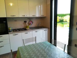 a kitchen with a table and a sink and a stove at Incantevole Villa Maddalena in Otranto +20 photos