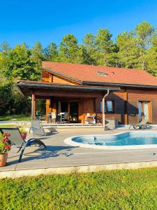 a house with a swimming pool in front of it at Chalet des Lacs in Marigny