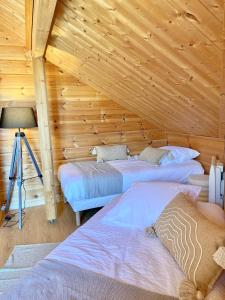 a room with three beds in a wooden cabin at Chalet des Lacs in Marigny +17 photos