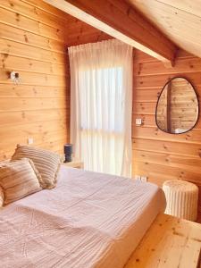 a bedroom with a bed in a wooden room at Chalet des Lacs in Marigny