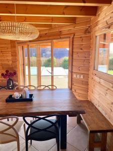a wooden dining room with a wooden table and chairs at Chalet des Lacs in Marigny