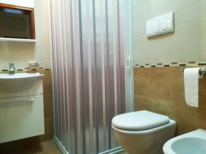 a bathroom with a shower and a toilet and a sink at Incantevole Villa Maddalena in Otranto