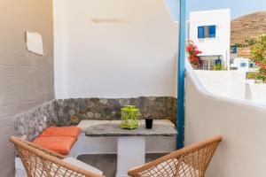 a patio with a table and chairs on a balcony at Porto Galini Kalloni in Agios Ioannis +17 photos