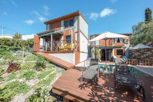 a house with a wooden deck and a swimming pool at Las Hermanas A in Guía de Isora