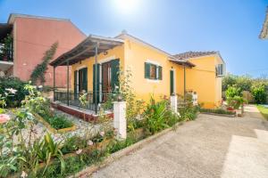 a house with a garden in front of it at Princess House in Sidari