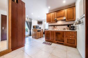 a kitchen with wooden cabinets and a tile floor at Au rêve savoyard 2 - 4 personnes in Morillon